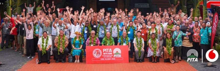 A group of conference delegates standing together in group photo setting at the Pacific Telecommunications Conference.