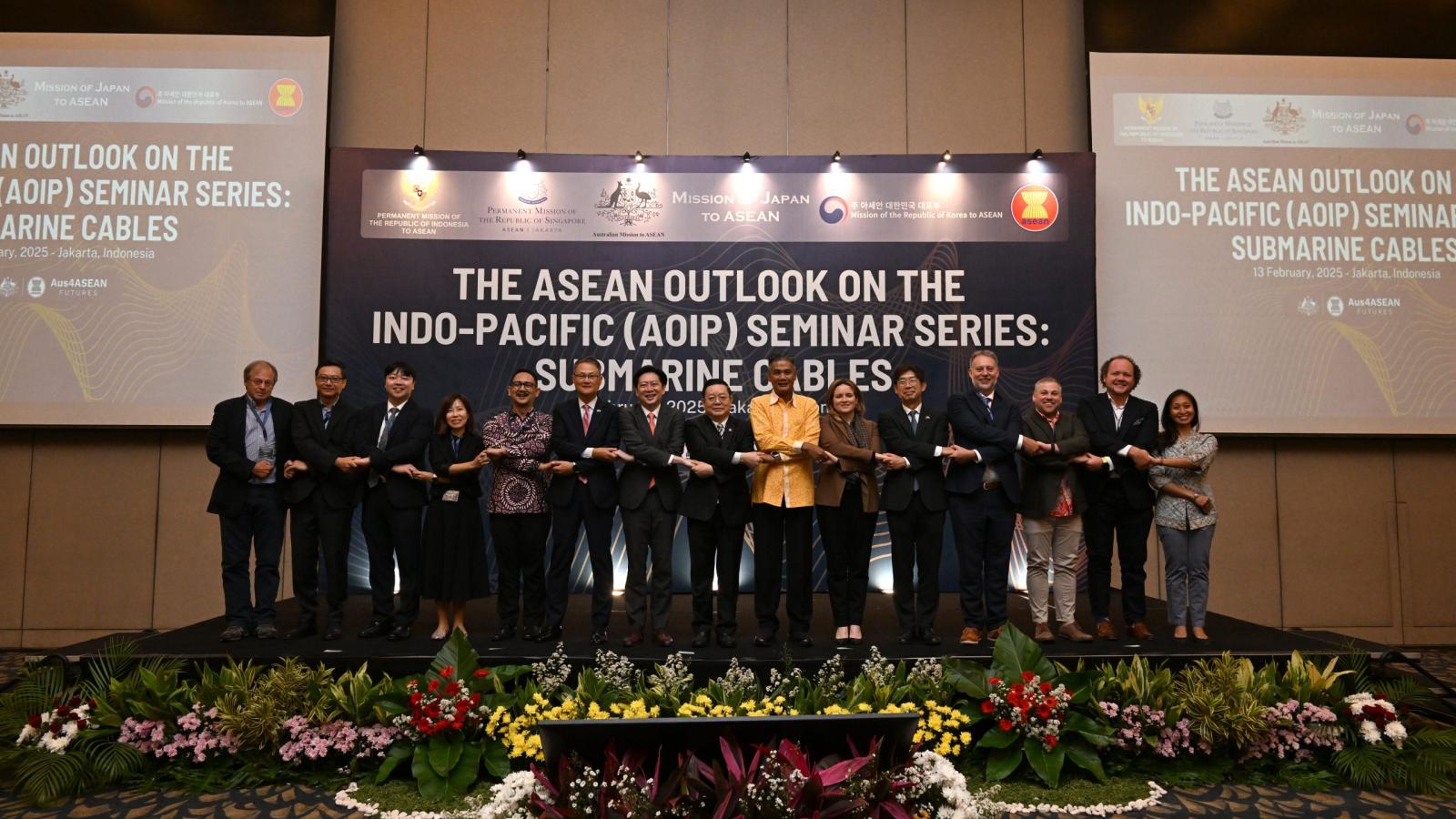 Representatives on stage at the ASEAN Outlook on the Indo-Pacific submarine cables seminar in Jakarta, standing arm-in-arm to mark regional cooperation on undersea cable resilience.