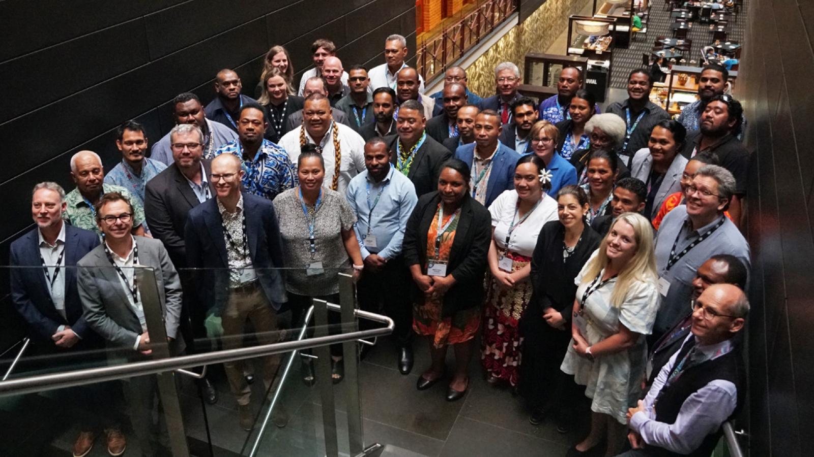 Large group of officials from Pacific Island countries and Timor-Leste standing on a stairwell during the Telecommunications and Radiocommunications Training Program in Melbourne.