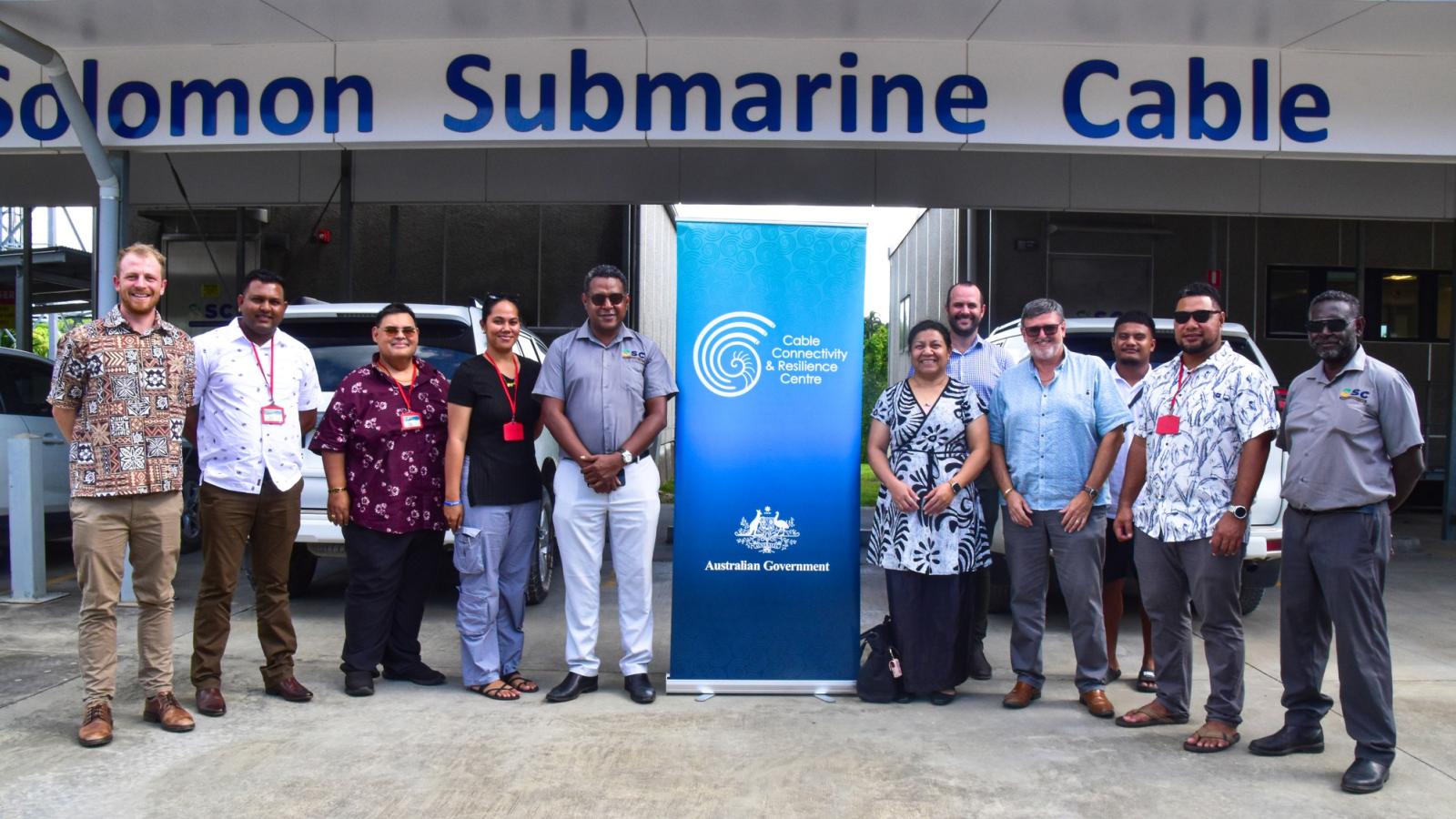 Representatives from the Solomon Islands Submarine Cable Company, Nauru Fibre Cable and Tuvalu Telecommunications Corporation standing outside the Solomon Islands cable landing station during a regional study tour.